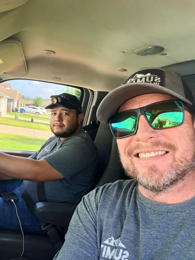 Two Summit Heating and Air crew members in the cab of a service truck